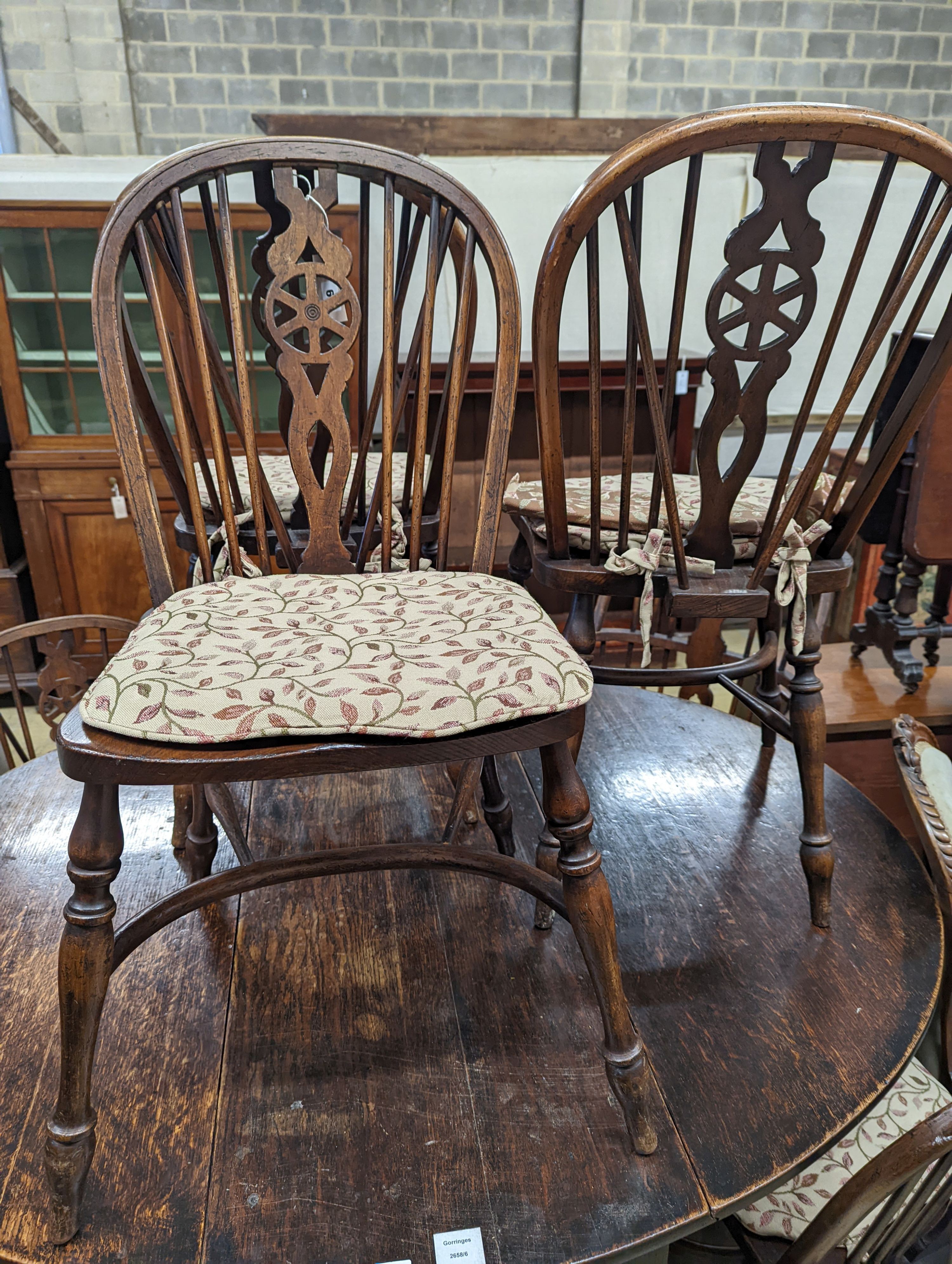 A wheelback Windsor elm and beech chair and six matching single chairs with crinoline stretchers, one with arms